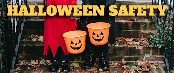 Two kids in costumes holding jack-o-lantern pails